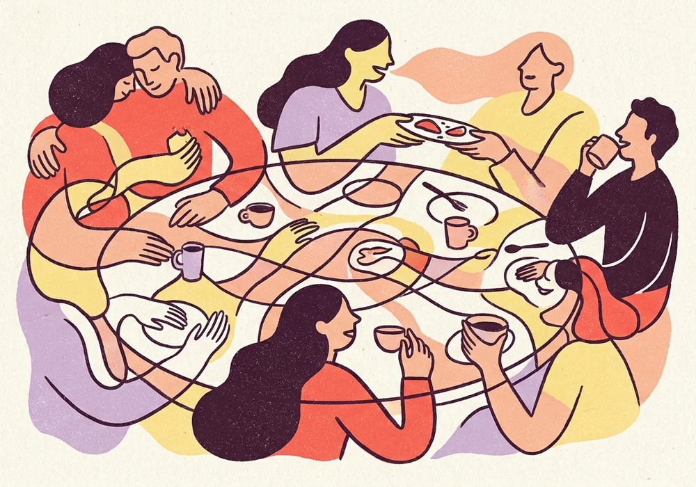 A group of adults sharing food and conversation around a table